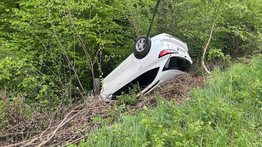 Auto verunglückt kopfüber im Wald bei Obermumpf. Fahrer im Spital, Polizei ermittelt zur Unfallursache.